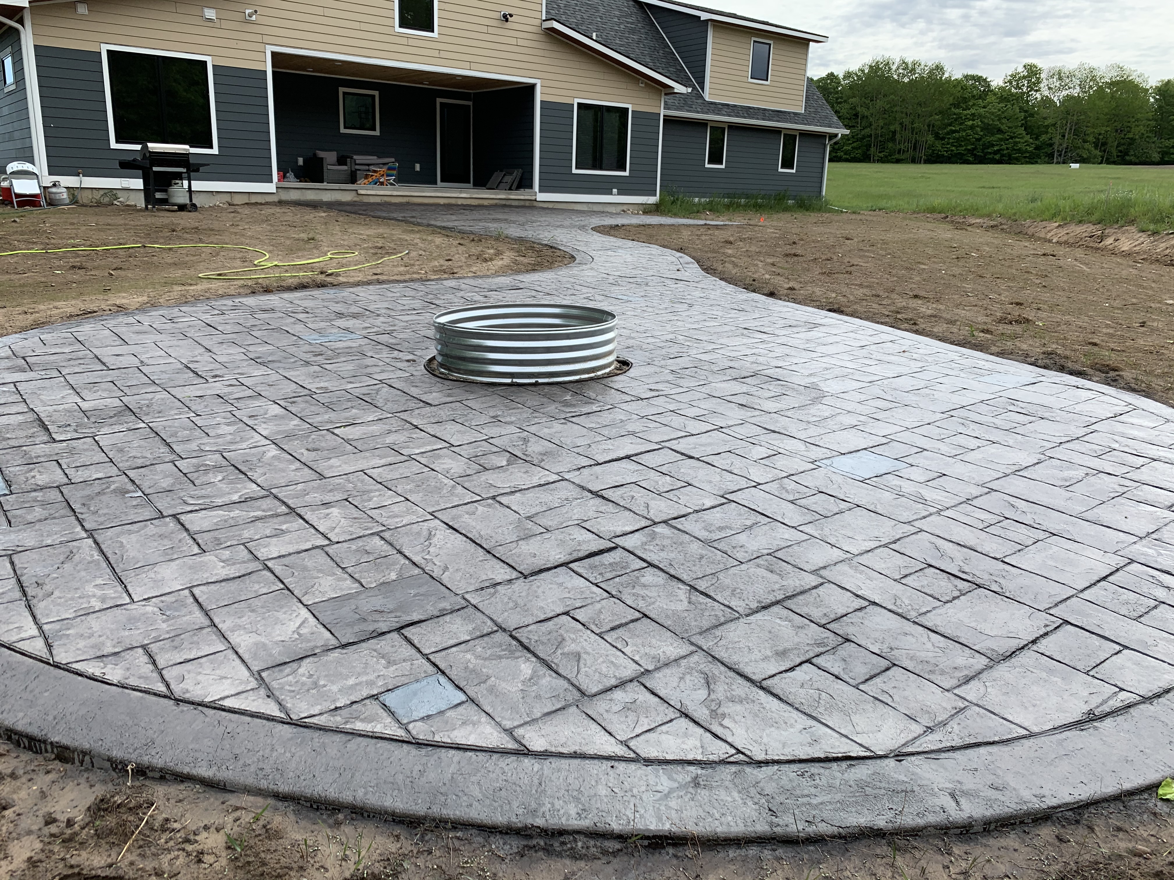 Stamped concrete patio with fire pit ring — Flaska project